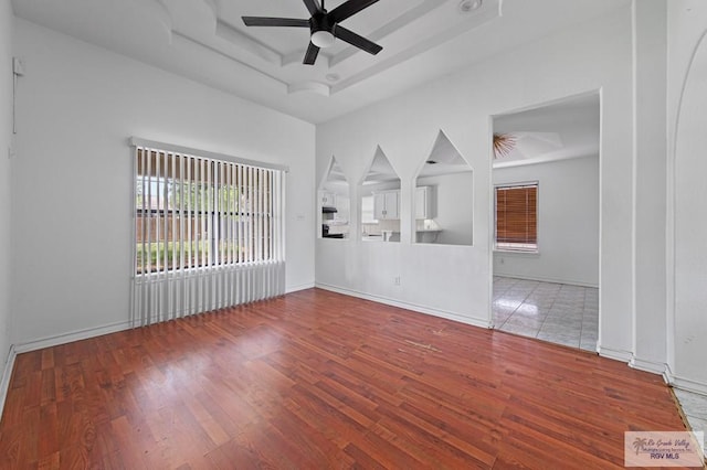 4217 W Ithaca Ave, Mcallen, TX 78501 - unfurnished living room with ceiling fan, wood finished floors, a raised ceiling, and baseboards