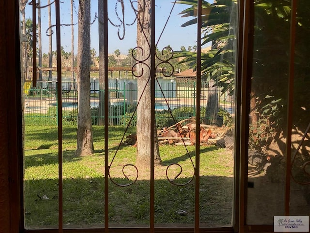 view of gate with fence and a lawn