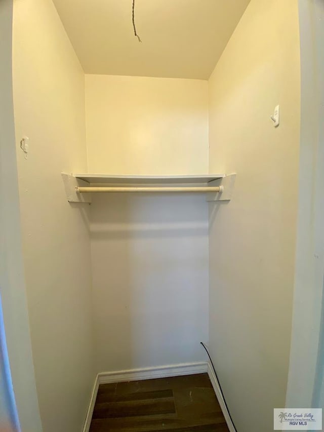 walk in closet with wood finished floors