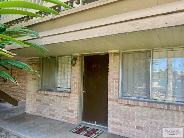 doorway to property featuring brick siding