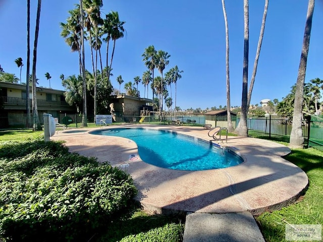 pool with fence and a patio