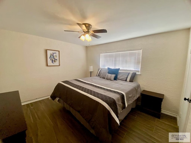 bedroom with a ceiling fan, wood finished floors, and a textured wall