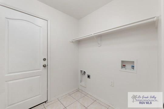 18186 King Palm Dr, Harlingen, TX 78552 - laundry room featuring washer hookup, hookup for an electric dryer, light tile patterned floors, and baseboards