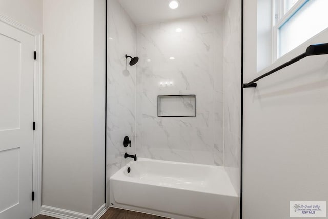 bathroom with hardwood / wood-style floors and tiled shower / bath combo