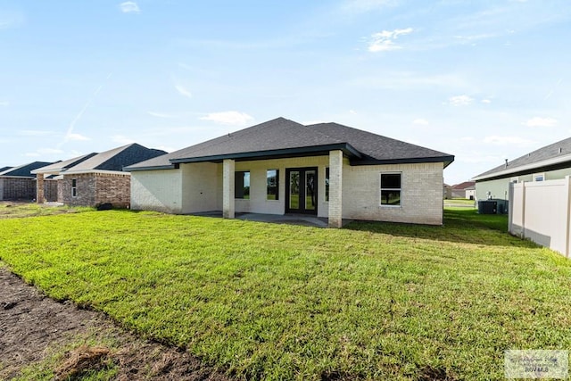 back of house with a yard and central AC