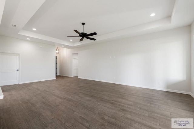 unfurnished room with a tray ceiling, hardwood / wood-style flooring, and ceiling fan