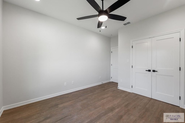 unfurnished bedroom featuring a closet, dark hardwood / wood-style floors, and ceiling fan