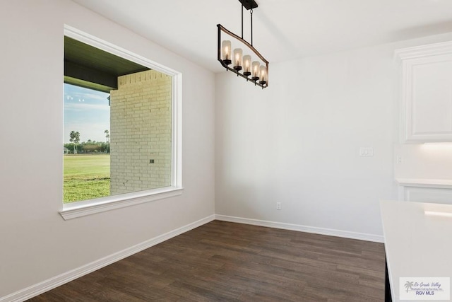 unfurnished dining area with dark wood-type flooring