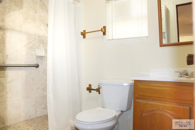 bathroom with curtained shower, vanity, and toilet