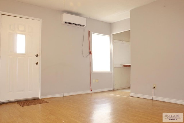 entrance foyer featuring a healthy amount of sunlight, light hardwood / wood-style flooring, and a wall mounted AC