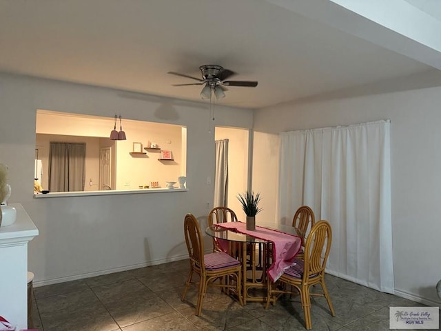 dining space featuring baseboards and a ceiling fan