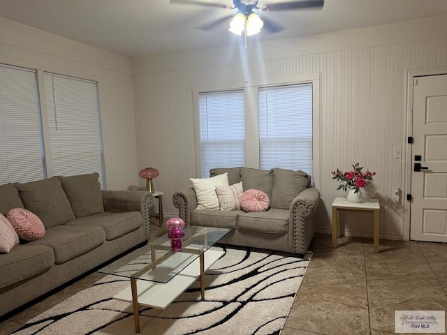 living area featuring a ceiling fan and baseboards