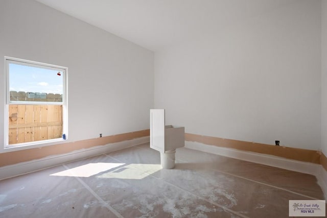 unfurnished room with baseboards