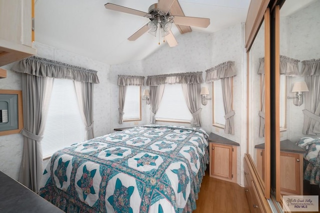 bedroom featuring hardwood / wood-style floors, vaulted ceiling, and ceiling fan