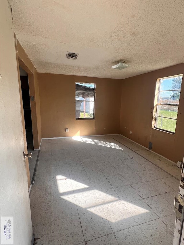 unfurnished room with a textured ceiling