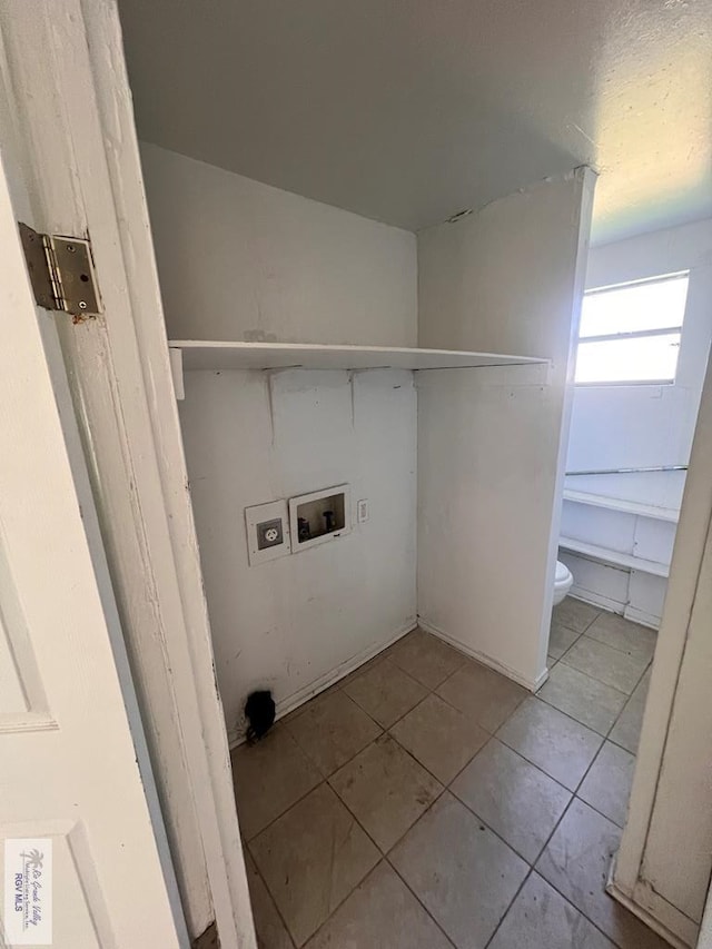 clothes washing area with light tile patterned floors and hookup for a washing machine