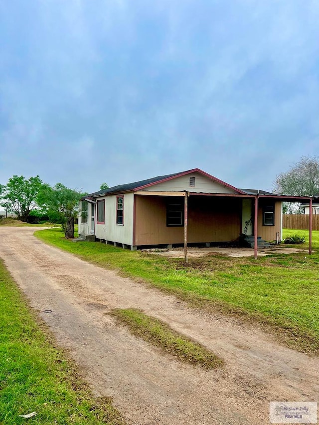 view of property exterior with a carport and a yard