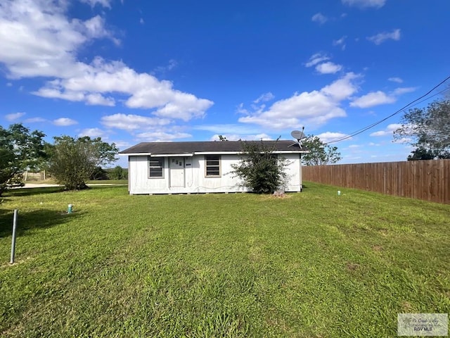 back of property featuring a lawn and an outdoor structure