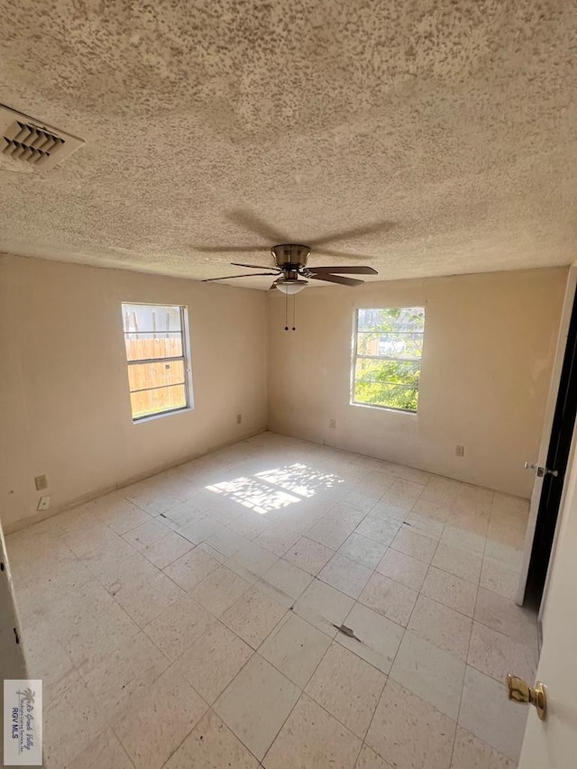 empty room with ceiling fan and a healthy amount of sunlight