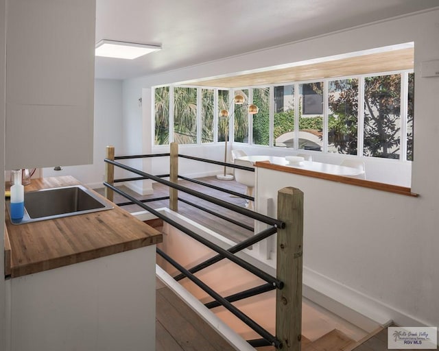 stairs featuring wood-type flooring and sink