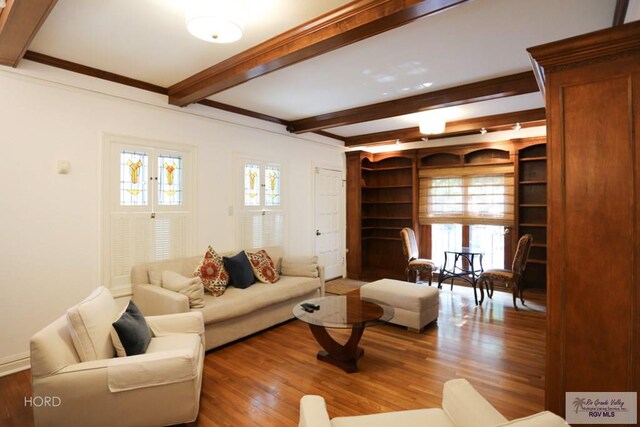 living room with beam ceiling, hardwood / wood-style floors, and ornamental molding