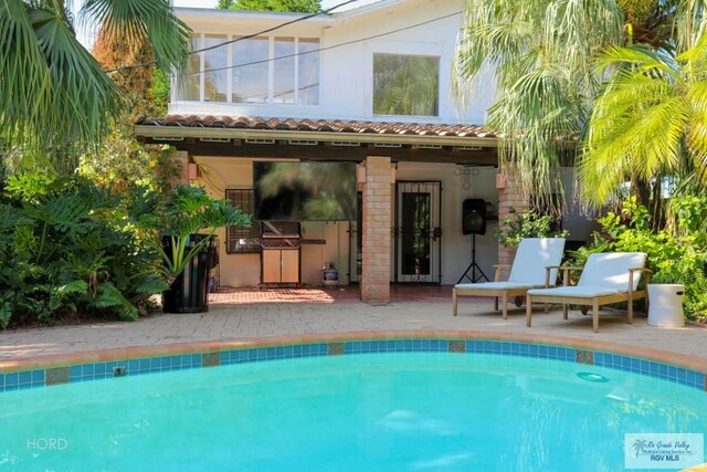 rear view of house featuring a patio area and exterior kitchen