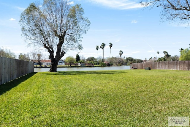 view of yard featuring a water view and fence