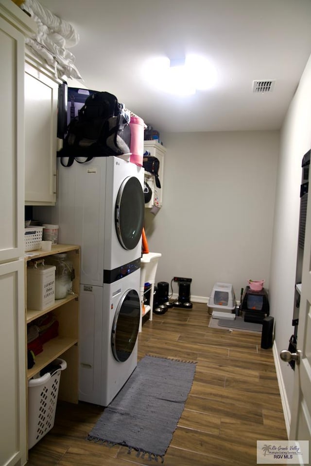 4080 Westland Dr, Brownsville, TX 78521 - laundry room with stacked washer and clothes dryer, dark wood finished floors, and cabinet space