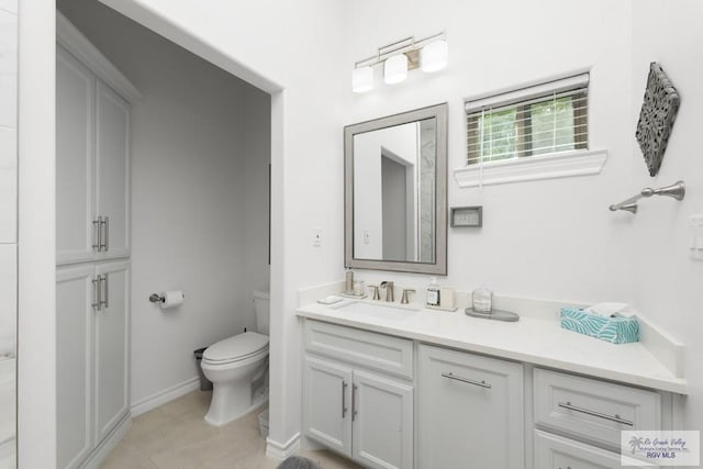 bathroom featuring tile patterned flooring, vanity, and toilet