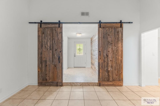 1000 E Palm Valley Dr, Palm Valley, TX 78552 - tiled foyer entrance featuring a barn door and baseboards