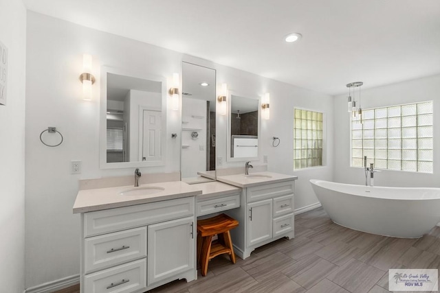 1000 E Palm Valley Dr, Palm Valley, TX 78552 - bathroom with double vanity, a freestanding tub, and recessed lighting