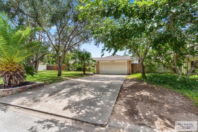 1000 E Palm Valley Dr, Palm Valley, TX 78552 - view of property hidden behind natural elements featuring driveway and brick siding