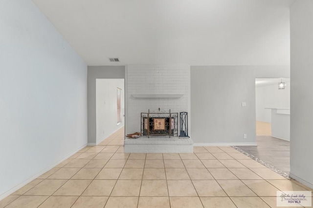 1000 E Palm Valley Dr, Palm Valley, TX 78552 - unfurnished living room with light tile patterned flooring and a brick fireplace