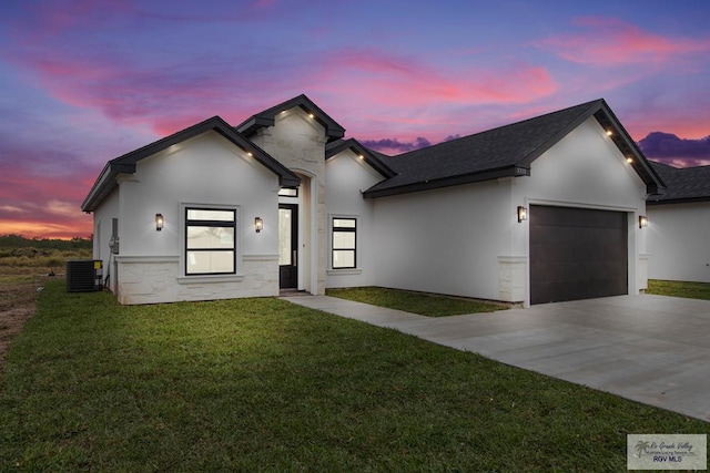 view of front of property with a garage, cooling unit, and a lawn