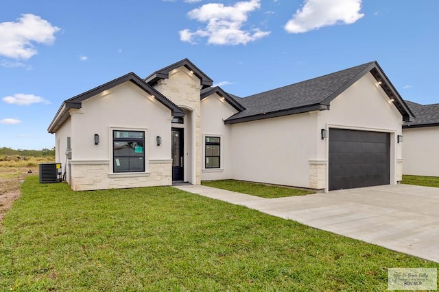 view of front of property with a garage, central air condition unit, and a front yard