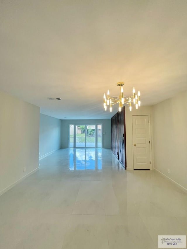 spare room with a notable chandelier