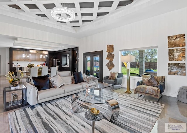 living room with plenty of natural light, coffered ceiling, and an inviting chandelier