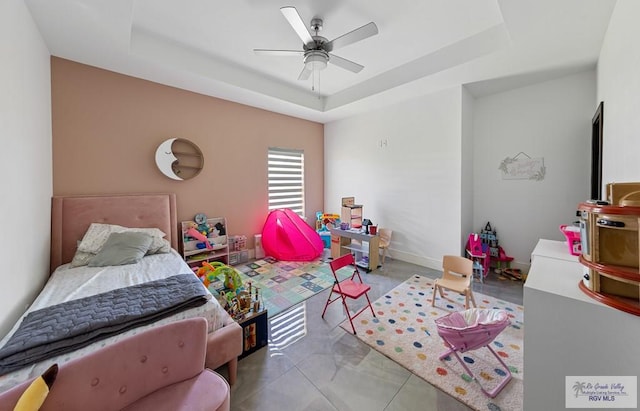 bedroom with a tray ceiling and ceiling fan