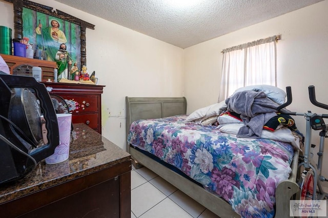 bedroom featuring light tile patterned flooring and a textured ceiling