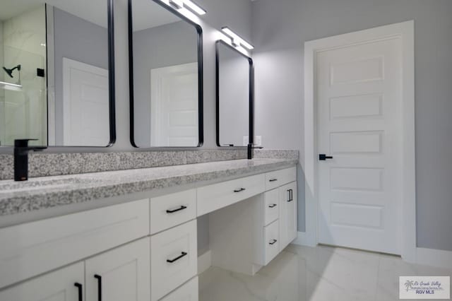 bathroom featuring double vanity, marble finish floor, a shower stall, and a sink