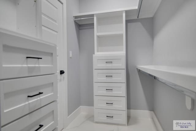 spacious closet with marble finish floor