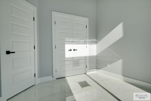 entrance foyer with baseboards and marble finish floor