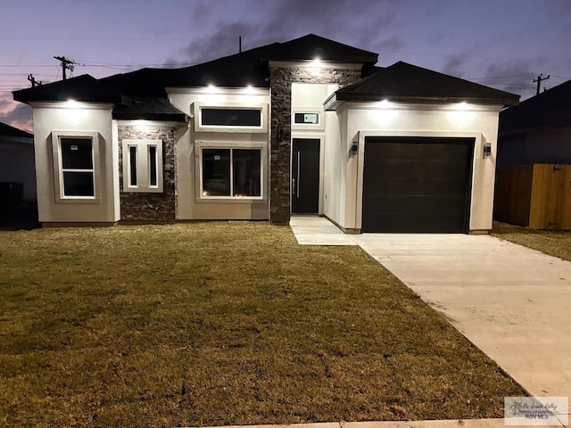 view of front of home featuring stucco siding, driveway, stone siding, an attached garage, and a front yard