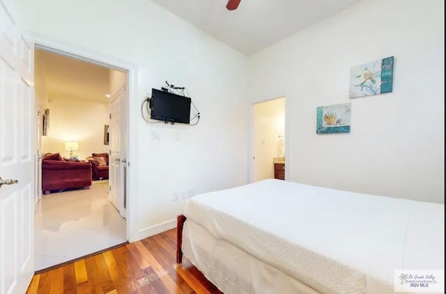 bedroom featuring ceiling fan, wood-type flooring, and ensuite bath