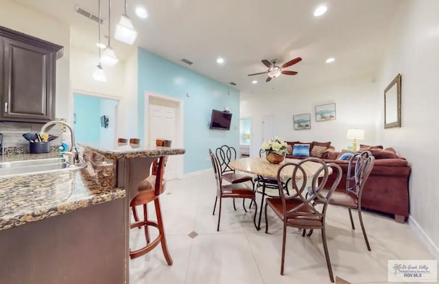 dining space featuring light tile patterned floors, ceiling fan, and sink