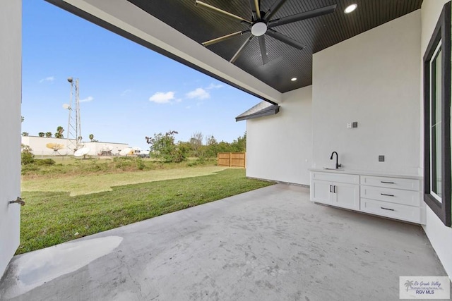 view of patio featuring ceiling fan and sink