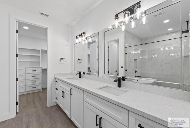 bathroom with hardwood / wood-style flooring, walk in shower, and vanity