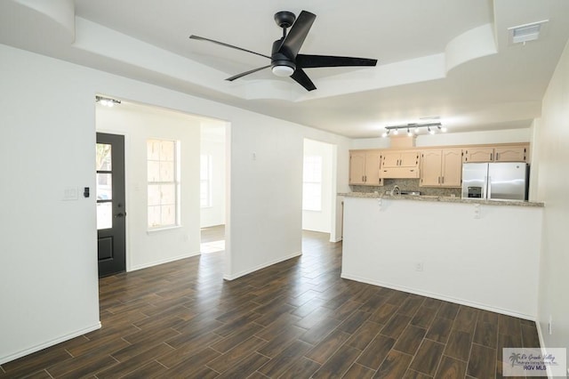 kitchen featuring light stone countertops, stainless steel refrigerator with ice dispenser, ceiling fan, light brown cabinets, and dark hardwood / wood-style floors