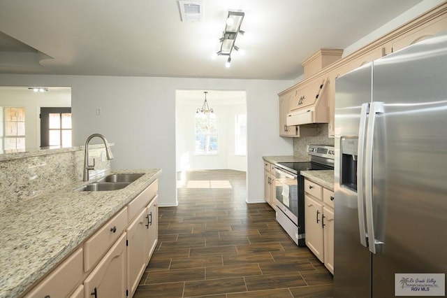 kitchen featuring hanging light fixtures, a healthy amount of sunlight, sink, and appliances with stainless steel finishes