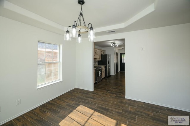 unfurnished dining area featuring dark hardwood / wood-style flooring and an inviting chandelier